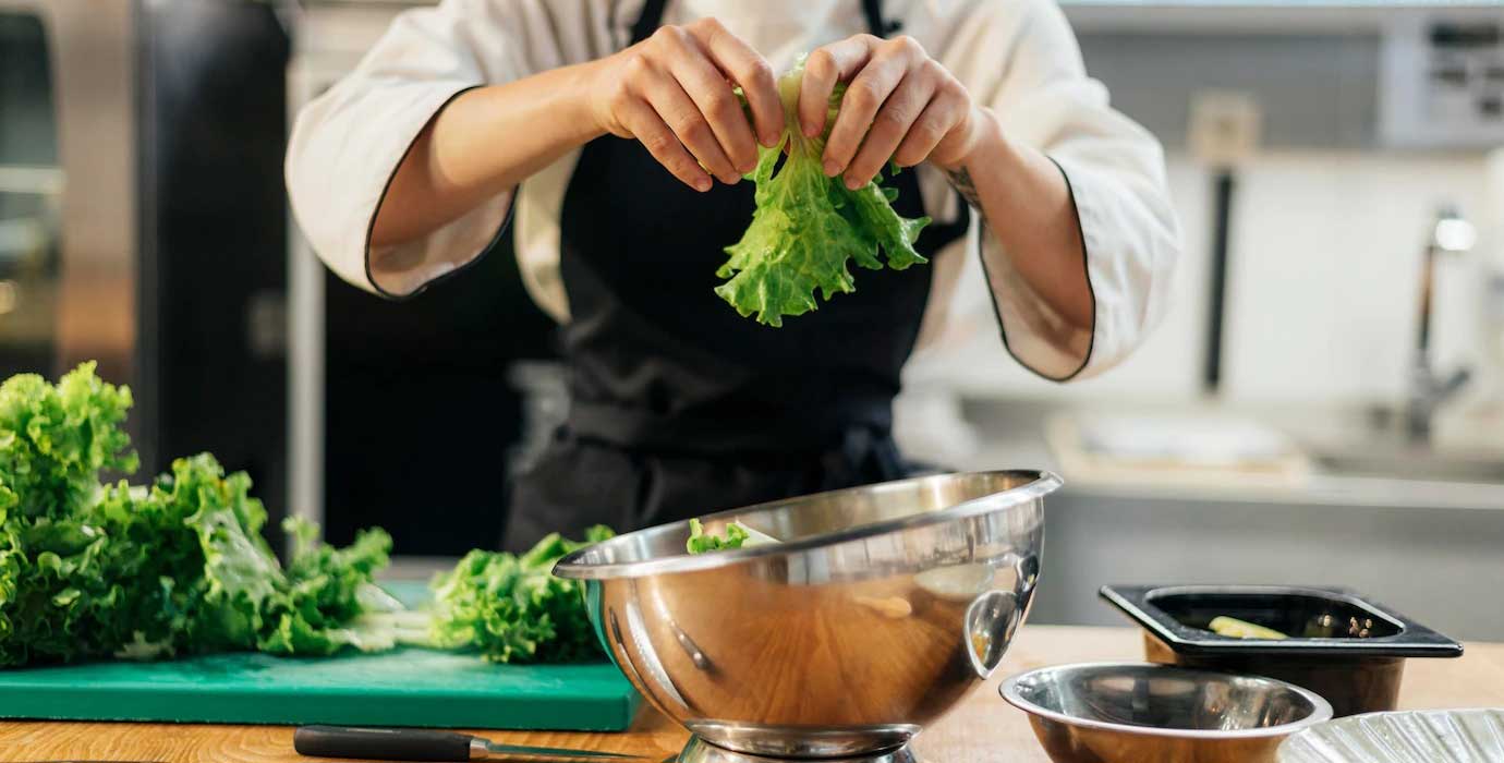 Front-View-Female-Cef-Tearing-Salad-Kitchen_23-2148763183